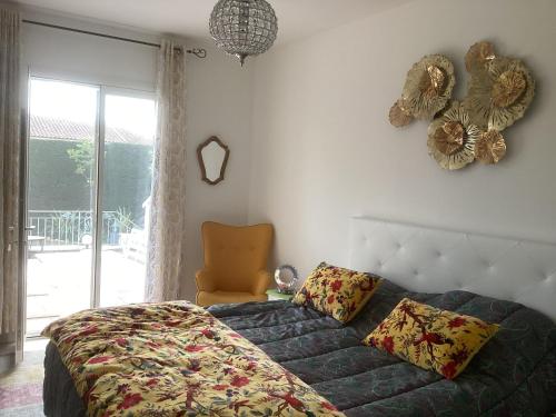 une chambre avec un lit, une chaise et une fenêtre dans l'établissement Charme au coeur des Alpilles - Villa Le Paradou, à Maussane-les-Alpilles