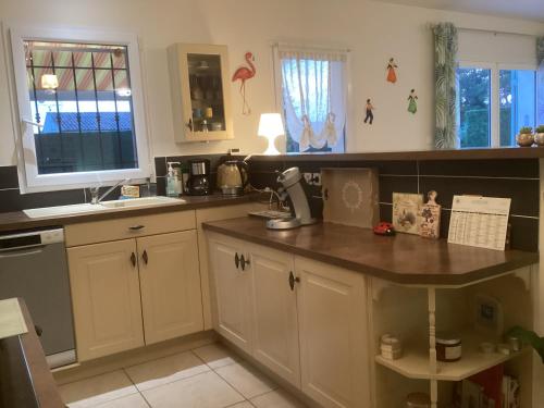 une cuisine avec des armoires blanches et un comptoir dans l'établissement Charme au coeur des Alpilles - Villa Le Paradou, à Maussane-les-Alpilles