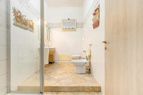 a small bathroom with a toilet and a shower at Monserrato Cozy Apartment near the Policlinico! in Monserrato