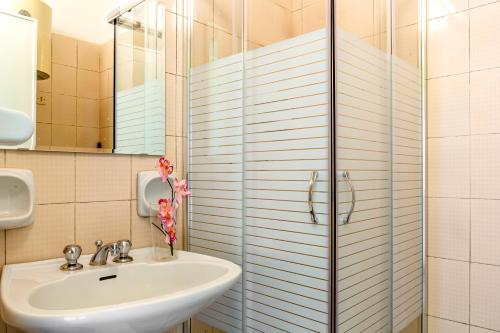 y baño con lavabo y ducha. en Iole's home, en Giardini Naxos