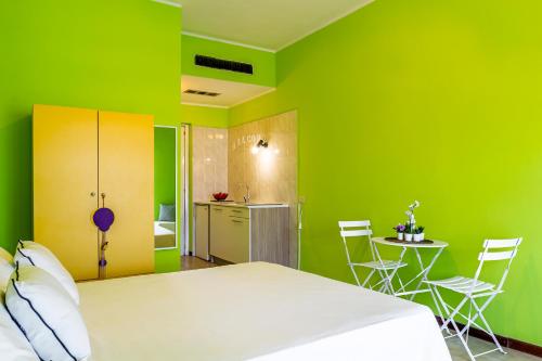 Habitación verde con cama, mesa y sillas en Iole's home, en Giardini Naxos