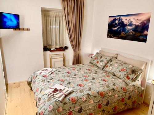 - une chambre avec un lit doté d'un couvre-lit fleuri dans l'établissement Stella Delle Alpi by Holiday World, à Pinzolo