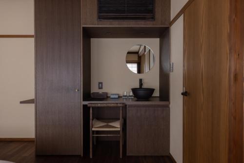 a bathroom with a vanity with a mirror and a sink at 杜人舎 Morito-Sha in Nanto