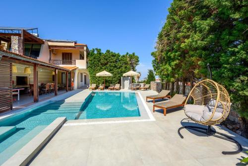 una piscina con sedia in vimini accanto a una casa di 3 Roses Residence a Afantou