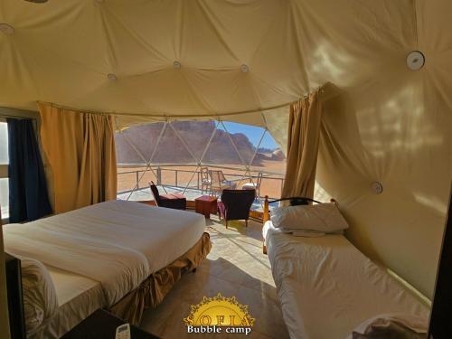 a bedroom with two beds and a view of the desert at Bubble Sofia Luxury Rum Camp in Wadi Rum