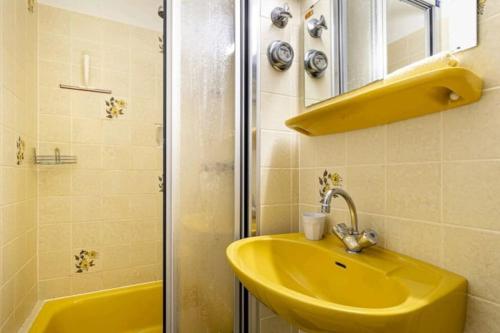uma casa de banho com um lavatório amarelo e um chuveiro em Apartment mit Kamin-Sonnendurchflutet-Balkon em Winterberg