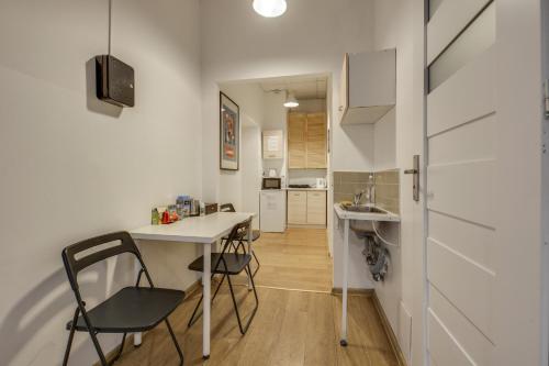 a kitchen with a table and chairs and a sink at Hostel Kattowitz in Katowice