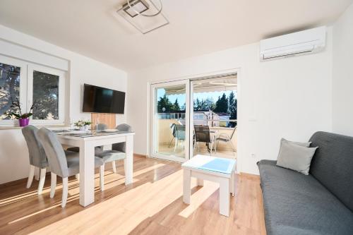 a white living room with a table and a couch at Apartma Morje in Savudrija