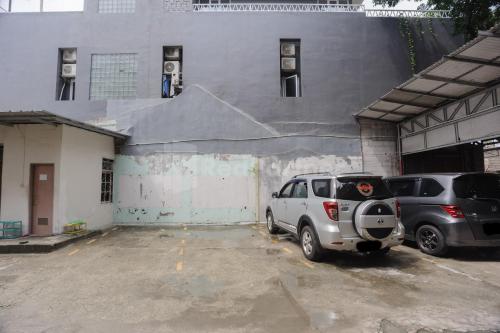 two cars parked in a parking lot next to a building at Rawa Buntu House RedPartner in Ciater-hilir