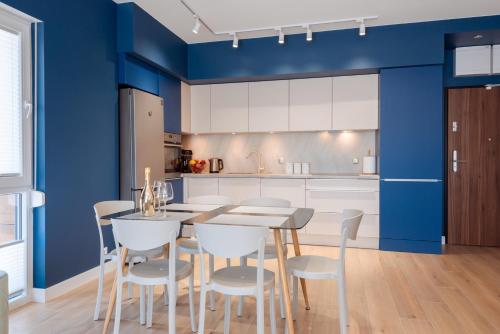 a kitchen with blue walls and a table and chairs at Blue Sea in Pogorzelica