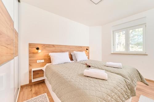 una camera bianca con un grande letto con due cuscini bianchi di Apartma Morje a Savudrija