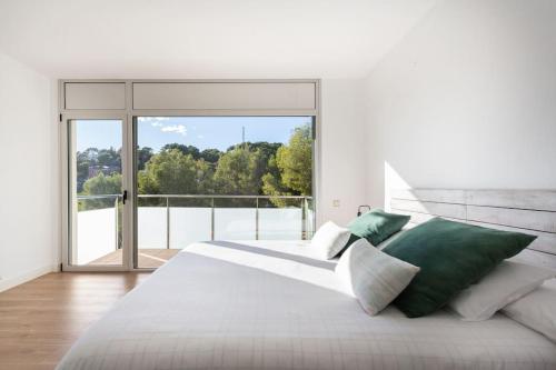 een slaapkamer met een groot bed en een groot raam bij Villa Paraíso in Castelldefels