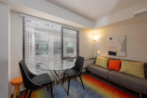 a living room with a couch and a table and chairs at Well located 1Bed Unit in near Albert Park w Gym! in Melbourne
