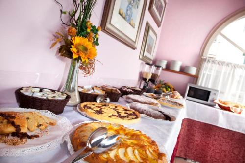 a table filled with different types of pastries and pies at My Home Hotel in Bellaria-Igea Marina