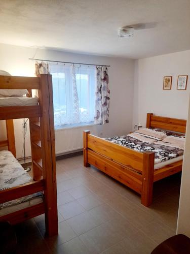 a bedroom with two bunk beds and a window at Apartmán u Zdeňků in Modrava