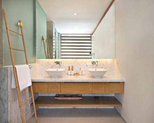 Un baño con dos lavabos y un espejo. en Danang Amazing Ocean Villas, en Da Nang