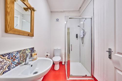 ein Bad mit einem Waschbecken, einer Dusche und einem WC in der Unterkunft 22 The Square in Londonderry County Borough