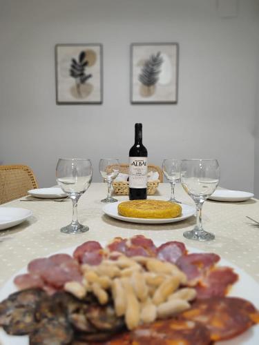 ein Tisch mit einem Teller Essen und einer Flasche Wein in der Unterkunft La casita de Ra in Castillo de Bayuela