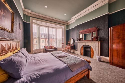 ein Schlafzimmer mit einem großen Bett und einem Kamin in der Unterkunft 22 The Square in Londonderry County Borough