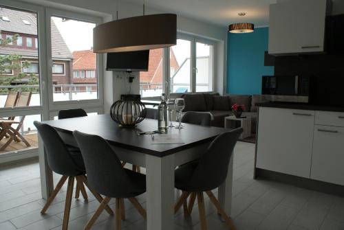 a kitchen and living room with a table and chairs at Strandhaus Rose in Juist