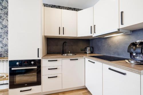 una cocina con armarios blancos y fregadero en Nice Renting - OFFENBACH - Luxury Apartment Fully Equipped Center en Niza