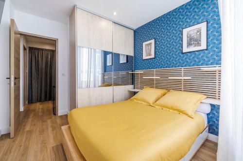 a bedroom with a yellow bed and a blue wall at Nice Renting - OFFENBACH - Luxury Apartment Fully Equipped Center in Nice