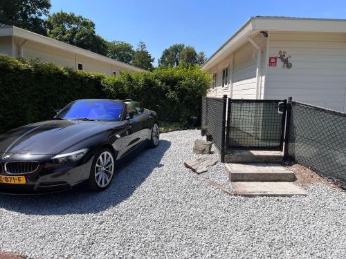 a black car parked in front of a house at Ibiza Style Holiday chalet in Susteren