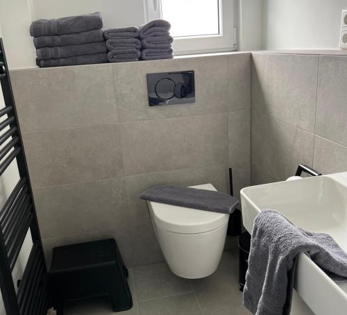 bagno con servizi igienici, lavandino e asciugamani. di Dünen Lodge 5 a Juist