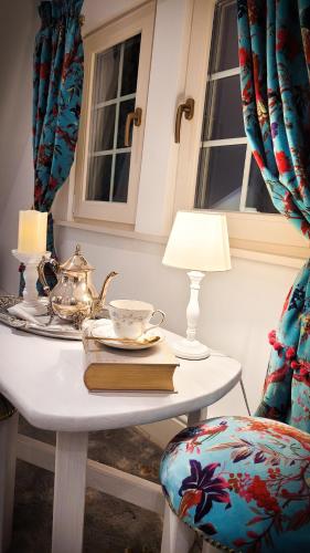 a table with a chair with a tea pot and a lamp at Carpathia Magic -adults only in Peştera