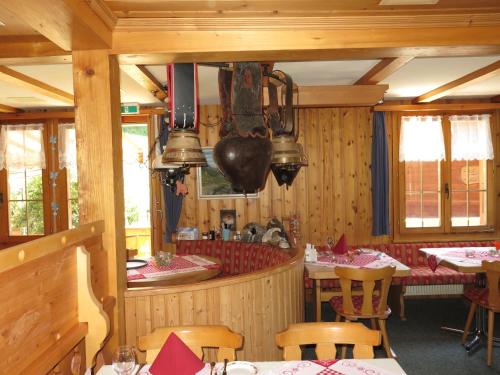a restaurant with wooden walls and tables and chairs at Ferienwohnung Uf dr Liwwi in Grindelwald