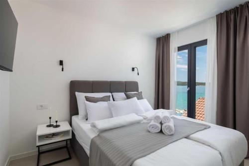 a bedroom with a large bed with towels on it at Luxury Seaside Villa L'Amour with pool in Sibenik - Zaboric in Zaboric
