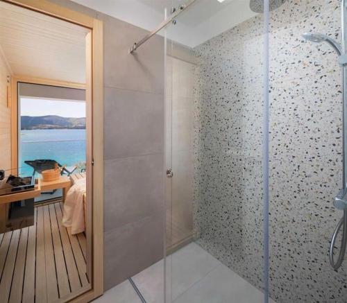 a bathroom with a shower with a glass door at Luxury Seaside Villa L'Amour with pool in Sibenik - Zaboric in Zaboric