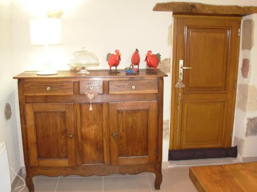 a wooden cabinet with chickens sitting on top of it at La Grange du Bourg in Deneuille-les-Mines