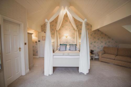 a bedroom with a canopy bed with blue pillows at Cragwood Country House Hotel in Windermere