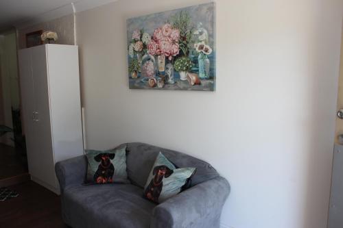 a couch in a living room with a painting on the wall at The Cosy House - Central Albury in Albury