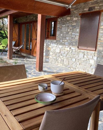 a wooden table with bowls on top of a patio at Cal Fray, San Martí d'Aravó, Puigcerdà in Guils de Cerdaña