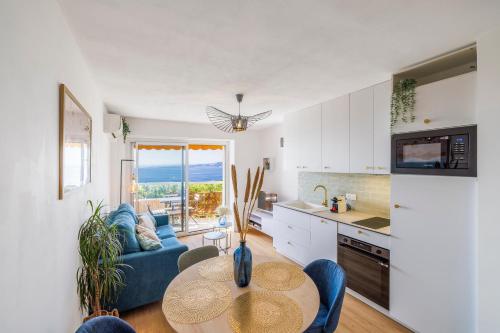 une cuisine et un salon avec une table et un canapé dans l'établissement Nice Renting - CARNOT - Escape to the French Riviera Terrace with Sea View, à Nice