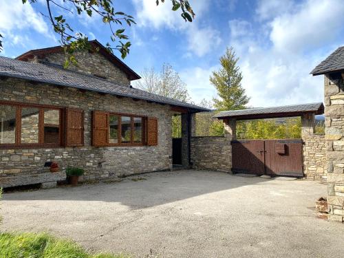 an old stone house with a large driveway at Cal Fray, San Martí d'Aravó, Puigcerdà in Guils de Cerdaña