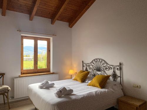 a bedroom with a bed with yellow pillows and a window at Cal Fray, San Martí d'Aravó, Puigcerdà in Guils de Cerdaña
