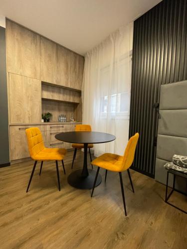 a dining room with a table and yellow chairs at Nowoczesne Apartamenty Stare Miasto in Częstochowa