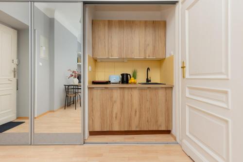 a kitchen with a door leading into a room at Sunny Studio Lwowska Street Metro by Renters in Warsaw