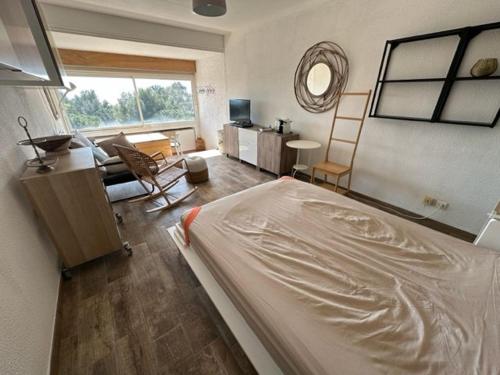une chambre avec un lit et un salon dans l'établissement Vue mer, plage des Sablettes à pied et climatisation, à La Seyne-sur-Mer