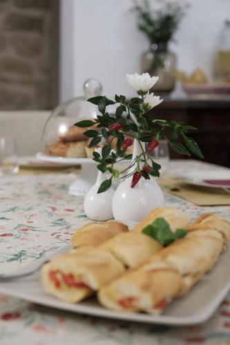 a plate of food with vases with flowers in them at Casa Catalé in Modica