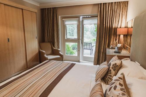 a hotel room with a bed and a window at Cragwood Country House Hotel in Windermere