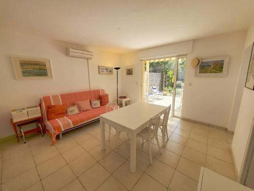 un salon avec un canapé et une table dans l'établissement Villa club 2 chambres avec grande terrasse dans résidence de vacances, à Six-Fours-les-Plages