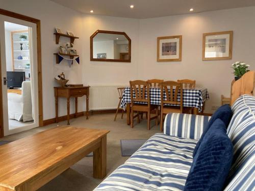 a living room with a couch and a table at Tenby Cottage with Parking in Tenby