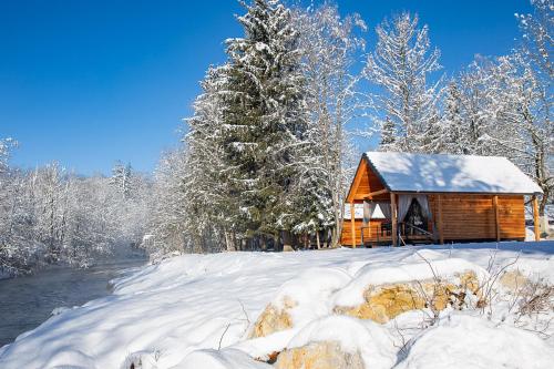 een houten hut in een met sneeuw bedekt bos bij Ranč Mackadam Ranch Mackadam in Tržič
