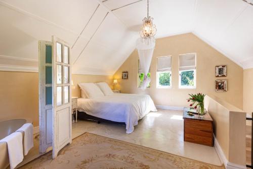 a bedroom with a bed and a chandelier at Devon Castle Orchard Cottage in Stellenbosch