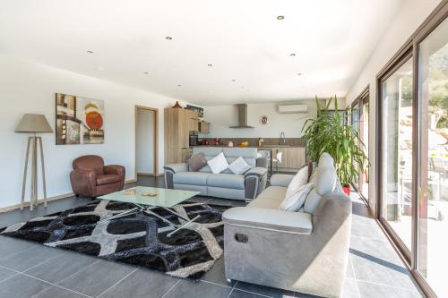 un salon avec un canapé et une table dans l'établissement Villa Kalliste, à Olmeto