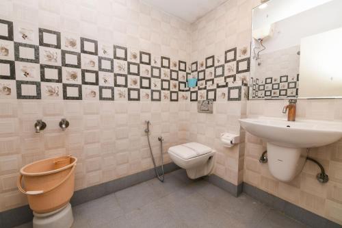 a bathroom with a toilet and a sink at Yuvraj Heritage Shelter Resort in Hosa Kannambādi